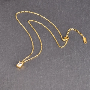 Detail of K18 hallmark on the gold square emerald necklace extension chain