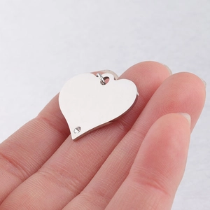 Close-up of a silver heart-shaped stainless steel pendant with a crystal detail