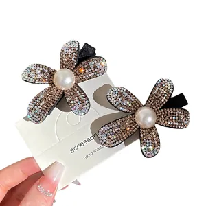 Pair of sparkling floral hair claws with colorful rhinestones and white pearls on gold base