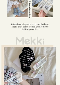 Detail of striped cotton crew socks featuring a square fabric patch with struggle lettering