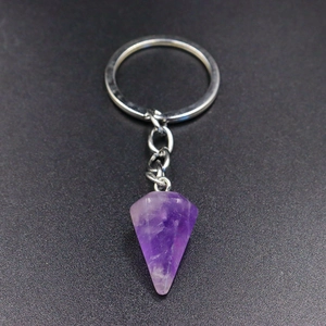 Macro detail of natural hexagonal amethyst crystal pendant with silver metal keychain
