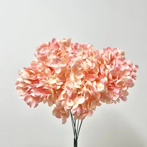 Detailed view of artificial pink hydrangea bouquet with realistic silk petals and green stems