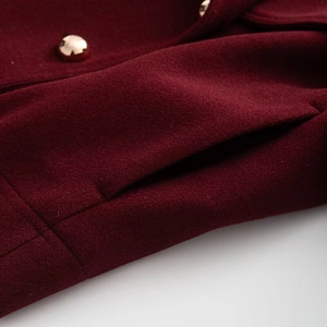 Detail view of burgundy wool blend jacket with golden metal button and side pocket
