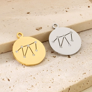 Close-up of gold and silver circular zodiac pendants with sparkling crystals on stone
