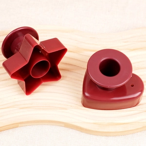 Detail view of heart and star shaped red donut molds on a wavy wooden tray for baking