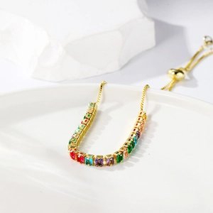 Close-up of adjustable gold bracelet with colorful square-cut rainbow cubic zirconia