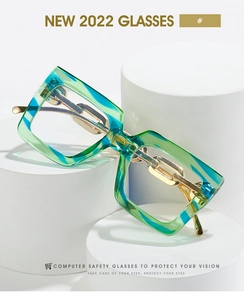 Detail of oversized square glasses featuring gold chain temples and blue marble frames