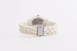 Detailed back view of a ladies watch with white textured strap and polished metal case