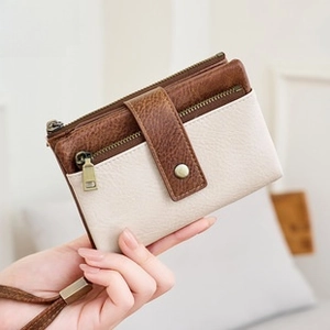 Detail of RFID blocking brown and beige travel wallet with wrist strap and zipper pocket