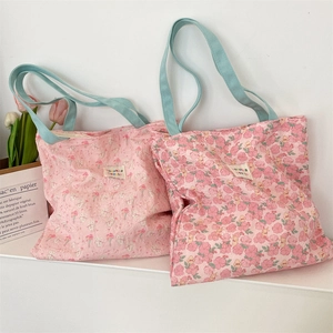 Detailed macro view of the pink floral fabric texture and light blue shoulder straps