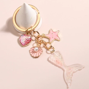 Detail of pink mermaid tail keychain with heart, shell, and starfish charms