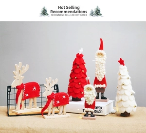 Detail of wool felt Christmas tree and wooden reindeer figurines for festive tabletop decor