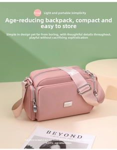 Detalle del bolso bandolera de nylon rosa con bolsillos de cremallera y correa ancha