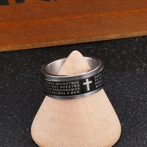 Macro detail of men's titanium ring featuring cross emblem and engraved religious text