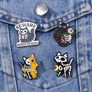 Cartoon Halloween cat skeleton enamel pin set on denim jacket featuring gothic text
