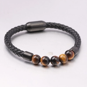Dettaglio di perline occhio di tigre da 6mm su bracciale in pelle intrecciata nera con fibbia