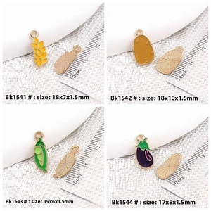 Detail showing enamel vegetable charms sizes: wheat, potato, pea pod and eggplant