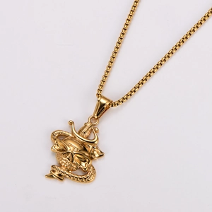Macro shot of gold skull and snake pendant with box chain on white background