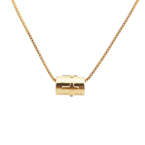 Close-up of golden cylindrical cross pendant with box chain on a white background