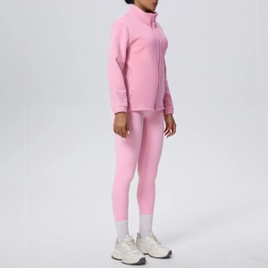 Dettaglio del set sportivo rosa con giacca in pile e leggings da yoga aderenti
