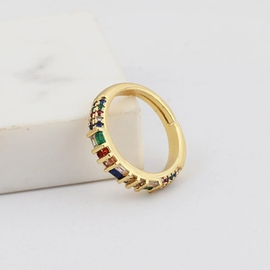Close-up of golden joint ring featuring a vibrant rainbow of multicolored gemstones