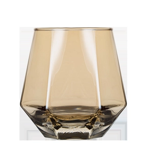 Amber hexagonal glass cup for whiskey or juice with geometric textured design on white background