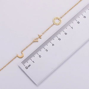 Detailed scale measurement of gold heart and moon pendants on a stainless steel bracelet