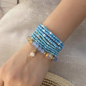 Macro detail of multi-layer Bohemian blue and white beaded bracelet with crystal charms