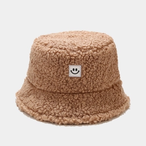 Close-up of caramel teddy fleece bucket hat texture with smiley face patch detail