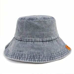 Dettaglio cappello pescatore in denim lavato azzurro con etichetta arancione decorativa