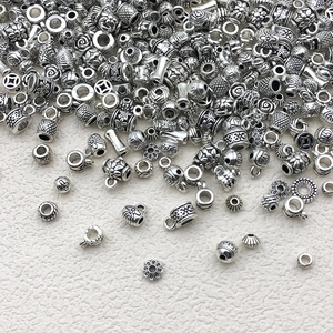 Detailed macro shot of various Tibetan silver alloy beads and floral spacer charms for DIY jewelry