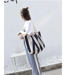 Detail view of large capacity striped canvas tote bag showing wide shoulder strap texture