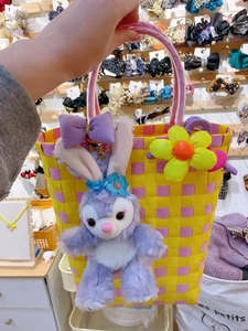 Detail of hand-woven bucket bag with plush rabbit charm and purple bow decoration