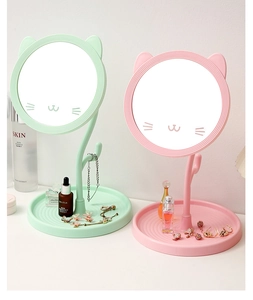 Close-up of cat-ear desktop makeup mirrors in mint green and pink with storage base