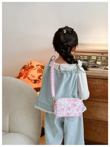 Detail of floral girl's crossbody bag featuring 3D pink flowers and lace ruffled strap