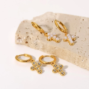 Macro shot of 18K gold plated cross hoop earrings with white pearls and sparkling zircons