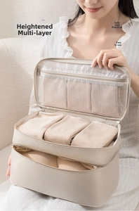 Detailed view of beige multi-layer travel organizer showing mesh pockets and bra compartments
