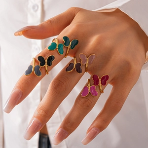 Close-up of colorful enamel butterfly rings in various shades with gold metal edges