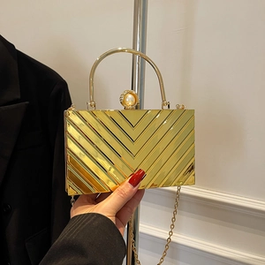 Golden V-pattern evening clutch bag with pearl clasp and sleek metal top handle