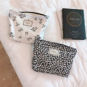 Detail of floral bubble fabric pouches with TIME TO PARTY labels and black zippers