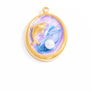 Macro shot of oval gold necklace pendant with blue-purple enamel and dolphin charm