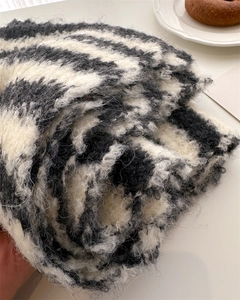 Close-up of soft zebra pattern wool scarf texture with plush fuzzy details on white desk