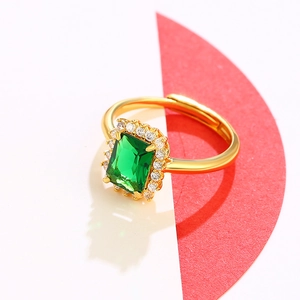 Luxurious gold ring with emerald-green rectangular gem and white crystals, adjustable band