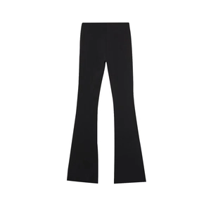 Dettaglio dei pantaloni neri a zampa elastici con trama liscia e design in tinta unita