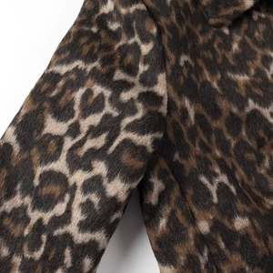 Dettaglio del polsino di un cappotto di lana leopardato con trama del tessuto