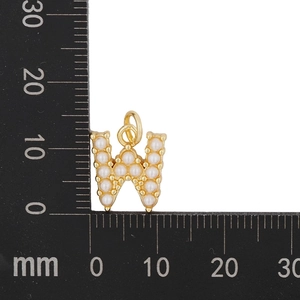Detailed view of gold letter W pendant with white pearls and metric scale measurement