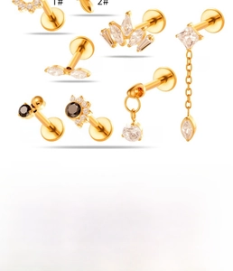 Close-up of assorted gold titanium lip rings with cubic zirconia in multiple designs