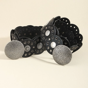 Detail of black wide leather belt featuring silver hammered buckles and ornate metal studs