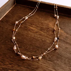 Vintage multi-layer tiger eye and irregular pearl beaded necklace on wooden tray