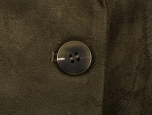 Macro view of dark brown suede fabric texture and matching resin four-hole button
